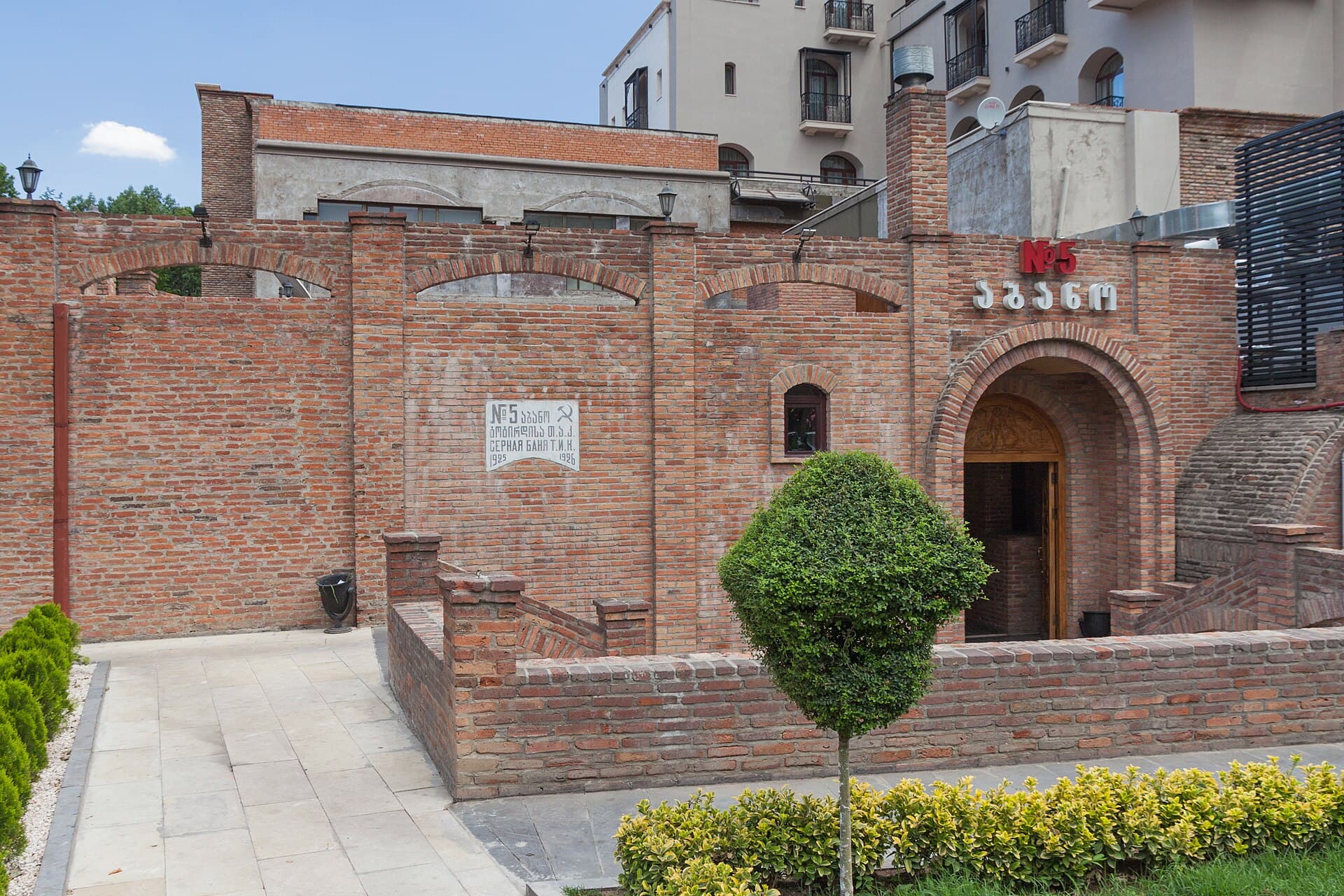 Brick façade and arched entrance of a historic sulfur bath house in Tbilisi’s Abanotubani district