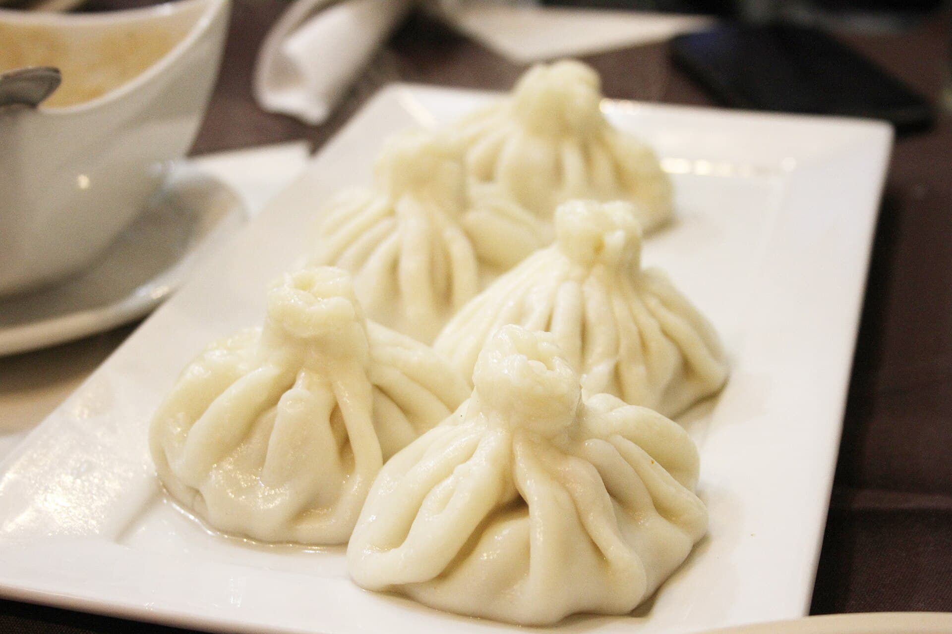 A plate of freshly made Georgian khinkali dumplings with their twisted dough crowns