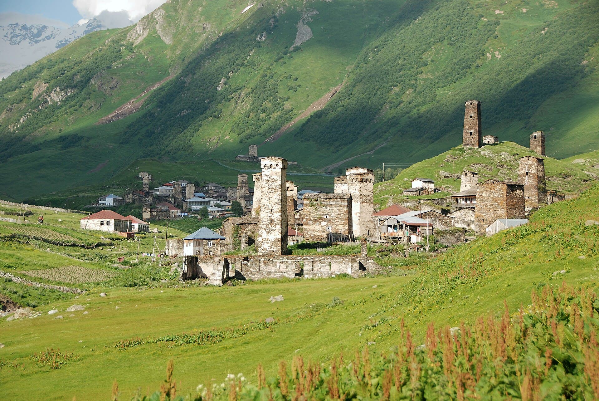 Medieval Svan watchtowers of Ushguli village beneath high green Caucasus slopes